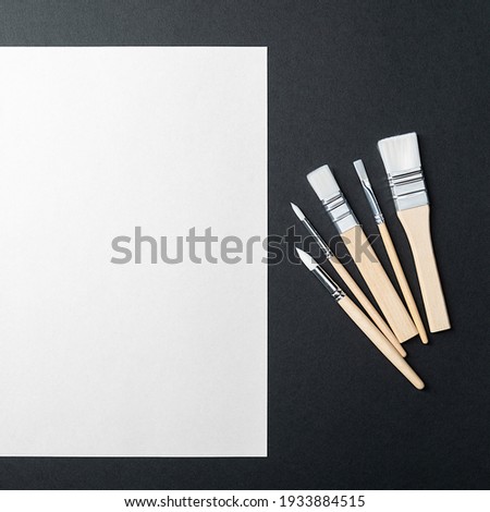 The sheet is pure white and the paint brushes are on a black background with a place to copy. Mock-up, mockup, layout.