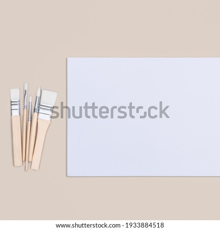 The sheet is pure white and the paint brushes are on a beige background with a place to copy. Mock-up, mockup, layout.