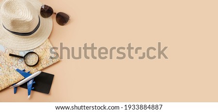 Straw hat, map, plane, sunglasses and magnifying glass on pastel background. Summer holiday, vacation, travel concept. Flat lay, top view, copy space. Banner Royalty-Free Stock Photo #1933884887