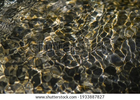 Closeup of restless surface of a mountain stream. Abstract water surface. Macro photography.