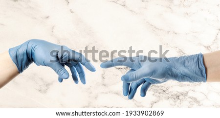 Hands with blue glove based on Michelangelo s painting of God creating man The Creation of Adam Royalty-Free Stock Photo #1933902869