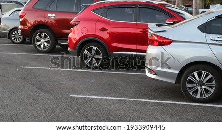 Closeup of rear, back side of blue car with  other cars parking in outdoor parking area in bright sunny day. Royalty-Free Stock Photo #1933909445