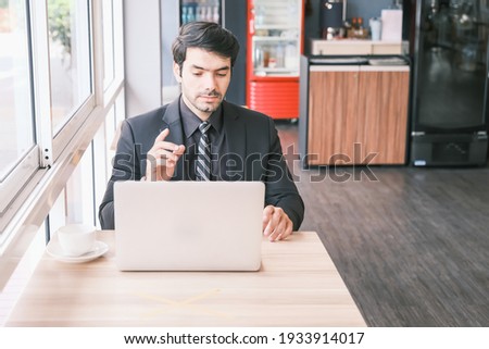 business caucasian man sitting in working in co working space near window