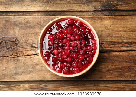 Fresh cranberry sauce on wooden table, top view