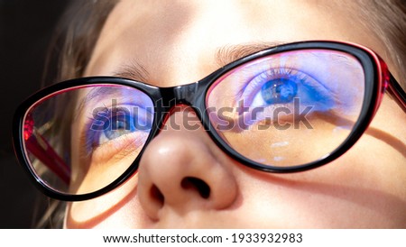 Close up of woman's eyes with red and black female glasses for working at a computer with a blue filter lenses. Anti blue light and rays. Eye protection Royalty-Free Stock Photo #1933932983