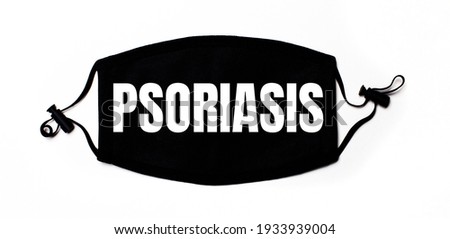 Black medical face mask on a light background with the inscription PSORIASIS. Disease prevention. Medical concept
