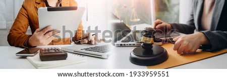 Business and lawyers discussing contract papers with brass scale on desk in office. Law, legal services, advice, justice and law concept Royalty-Free Stock Photo #1933959551