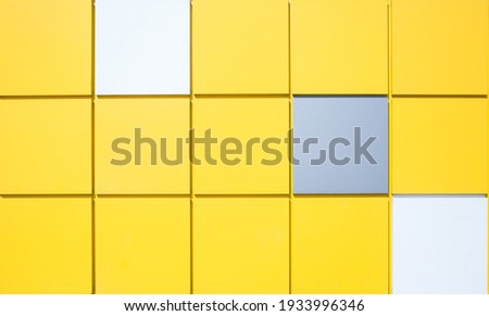 Bright yellow, white and gray square plastic wall panels. Modern trendy design. The main color trend of 2021. Place for writing text, announcements, advertisements