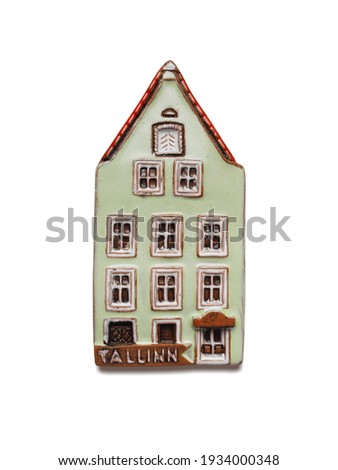 Fridge magnet. A souvenir from Tallinn in the form of a traditional Estonian house. Popular souvenirs and tourist collectibles. Close-up photo on a light background.