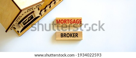 Mortgage broker symbol. Concept words 'Mortgage broker' on wooden blocks on a beautiful white backgrounds. Wooden model of house. Business, mortgage broker concept.