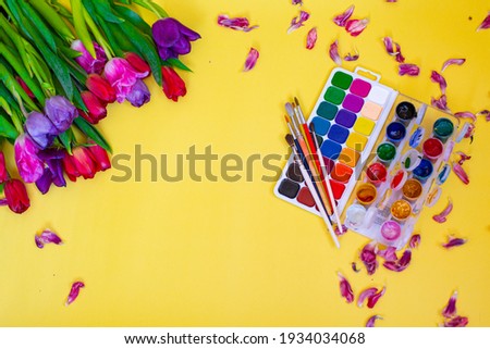 Creative layout with aquarelle palette, paint brushes on yellow background