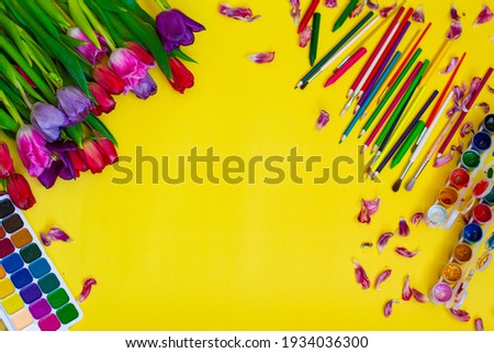 Creative layout with aquarelle palette, paint brushes on yellow background