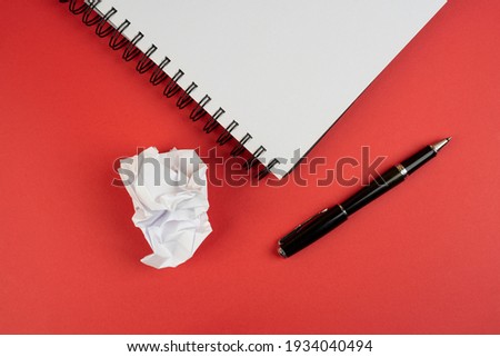 a pen and a crumpled sheet of paper