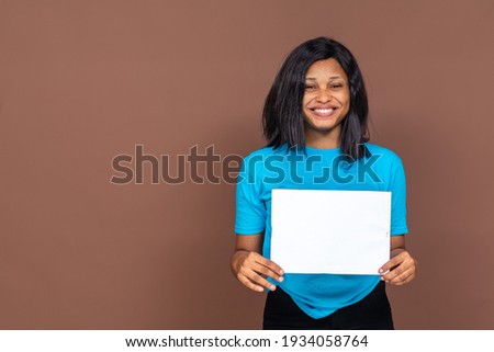 beautiful black lady holding up an empty banner, she is happy and has a smile on her face