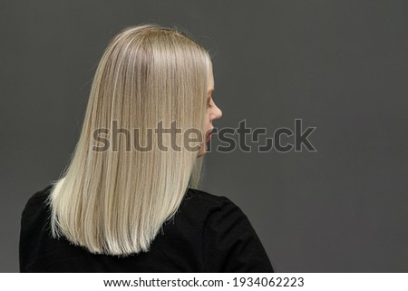Blonde model with straight hair, look from behind. Hair bleaching result. Space for text Royalty-Free Stock Photo #1934062223