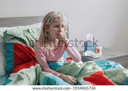 Sick ill kid girl with fever lying in bed at home with flu, fever, running nose and coughing in hand fist. Virus cold season flu cornavirus covid-19 illness disease. Medicine and health care concept.
 Royalty-Free Stock Photo #1934065736