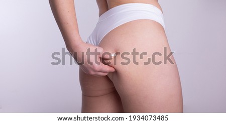 A woman using pinch test as one of the methods for measuring body fat stock photo
