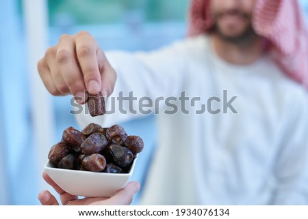 Muslim couple sharing dates for starting iftar Royalty-Free Stock Photo #1934076134