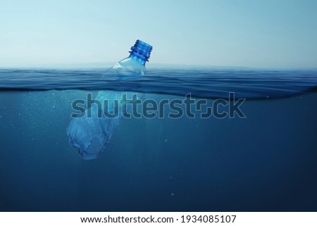 Garbage plastic bottle floats in blue sea water with underwater. Pollution of the environment and oceans.  Royalty-Free Stock Photo #1934085107