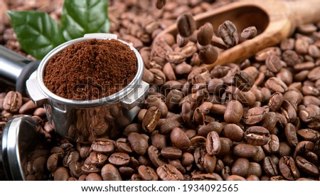 Falling Roasted Coffee Beans on Brown Background, close-up. Royalty-Free Stock Photo #1934092565
