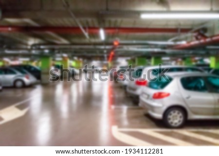 Garage interior blurred. Car lot parking space in underground city garage. Empty road asphalt background in soft focus. Large private garage