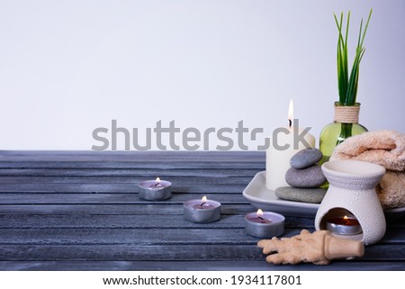 spa concept. zen stones, essential oil, candles and towel on a wooden background with space for text. High quality photo