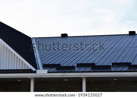 Newly installed metal roof showing vents, trough, angles and ice stops. Royalty-Free Stock Photo #1934135027
