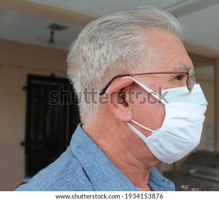 Side profile of an elderly Hispanic man wearing double or two face mask to protect from coronavirus or covid-19 outbreak - concept of safety, healthcare, medical and hygiene.