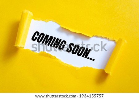 Text COMING SOON appearing behind torn yellow paper. For your design, concept.