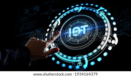 Internet of things - IOT concept. Businessman offer IOT products and solutions. Young businessman  select the abstract chip with text IoT on the virtual display. 