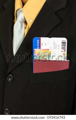 Businessman with passport, boarding pass, and banknote in pocket