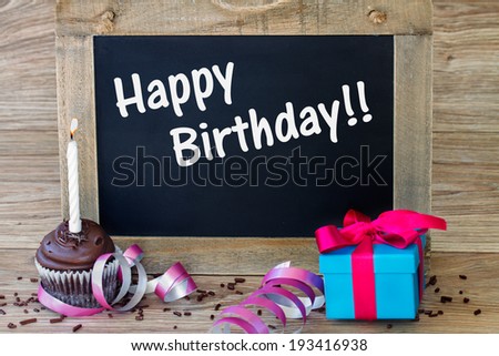 birthday greetings on black chalkboard with  cupcake and gift box