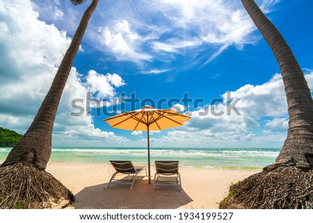 Sunbeds under tropical palms on beach on Phu Quoc island, Vietnam. Beach's smile Royalty-Free Stock Photo #1934199527