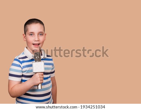 Funny child performs. Boy sings a song into the microphone. Talented child sings karaoke. Boy singing. Billboard or banner design. Photography for web pages, schools, special classes for children.