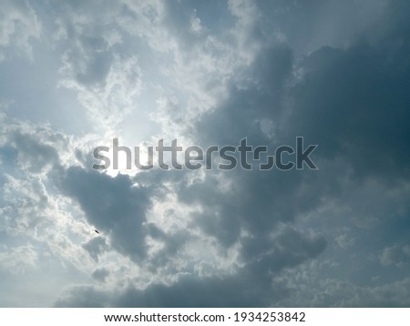 Beautiful dark clouds on sky background. Nature photography. Sun behind the dark clouds. Big or tiny and soft dark fluffy clouds in the sky. Full of cloudy sky background