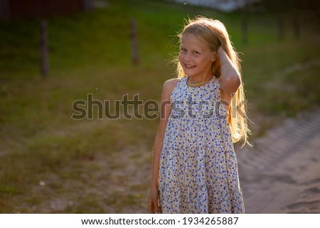 blonde girl runs on the sand at sunset, selective focus