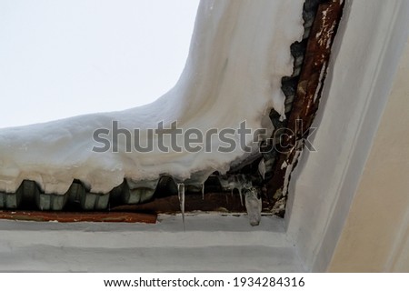snow cap and icicles on the roof of the building. High quality photo