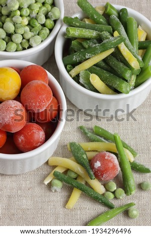 Frozen vegetables assorted in bowls isolated on white background, closeup, saving leftovers, food storage concept and eating meals at home concept