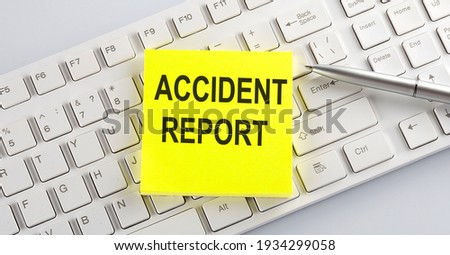 Words ACCIDENT REPORT written on yellow stickers on a computer keyboard