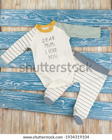 White Body with pants baby with inscription on wooden background