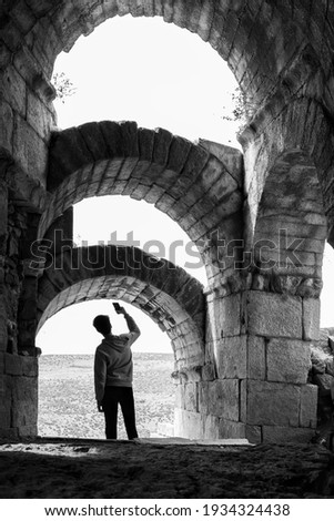 A young boy takes a picture at the ruins of Aigai Ancient City. Manisa, Turkey. 