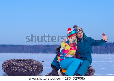 Wintersport Activities. Lovely Caucasian Couple Having Tube Activities In Winter Time And Posing Together For Taking Selfie Outdoor. Horizontal Image
