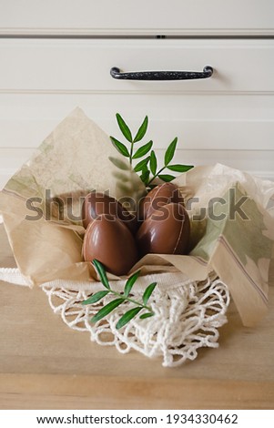 Happy Easter composition of four chocolate eggs in the modern style kitchen. DIY holiday decor for kids.