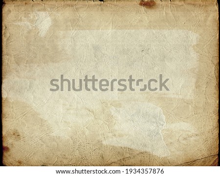 Stained, dirty, and distressed cream white, brown, orange, and tan vintage paper texture. Folded and faded, torn, ripped, peeling and creased from old age.  Royalty-Free Stock Photo #1934357876