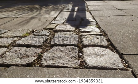 View of granite cubes stacked in a row between outdoor tiles, photo