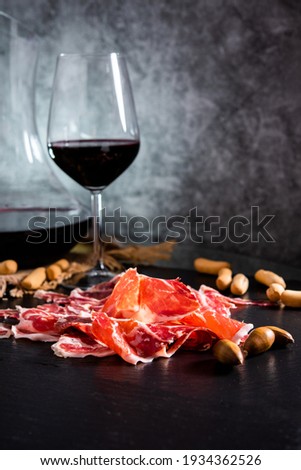 Iberian Ham. acorn-fed Iberian ham. Iberian ham with a glass of wine Royalty-Free Stock Photo #1934362526
