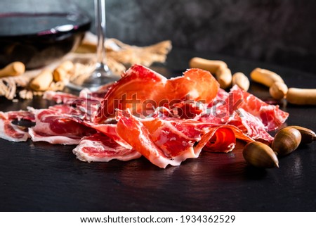 Iberian Ham. acorn-fed Iberian ham. Iberian ham with a glass of wine Royalty-Free Stock Photo #1934362529