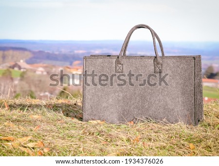 Gray felt bag in the natural habitat, image for advertising slogan Royalty-Free Stock Photo #1934376026