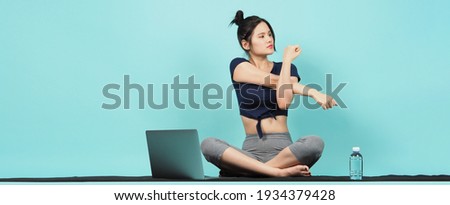 Fitness influencer. Sporty woman Blogger. workout training online via laptop. blue green background. Training woman KOL in sportswear shoots video exercise online. Exercises at home. notebook camera. 