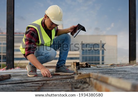 Civil Engineer people wearing safety helmets while inspection detail of raw material, Reinforcement bar concrete on construction site. Surveyor and checking concrete structure building. Royalty-Free Stock Photo #1934380580